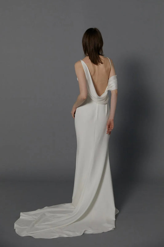 The draped off-shoulder asymmetrical neckline gives a modern take on a classic design wedding dress.