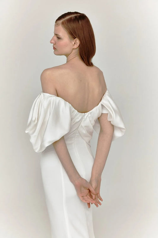 The draped off-shoulder asymmetrical neckline gives a modern take on a classic design wedding dress.