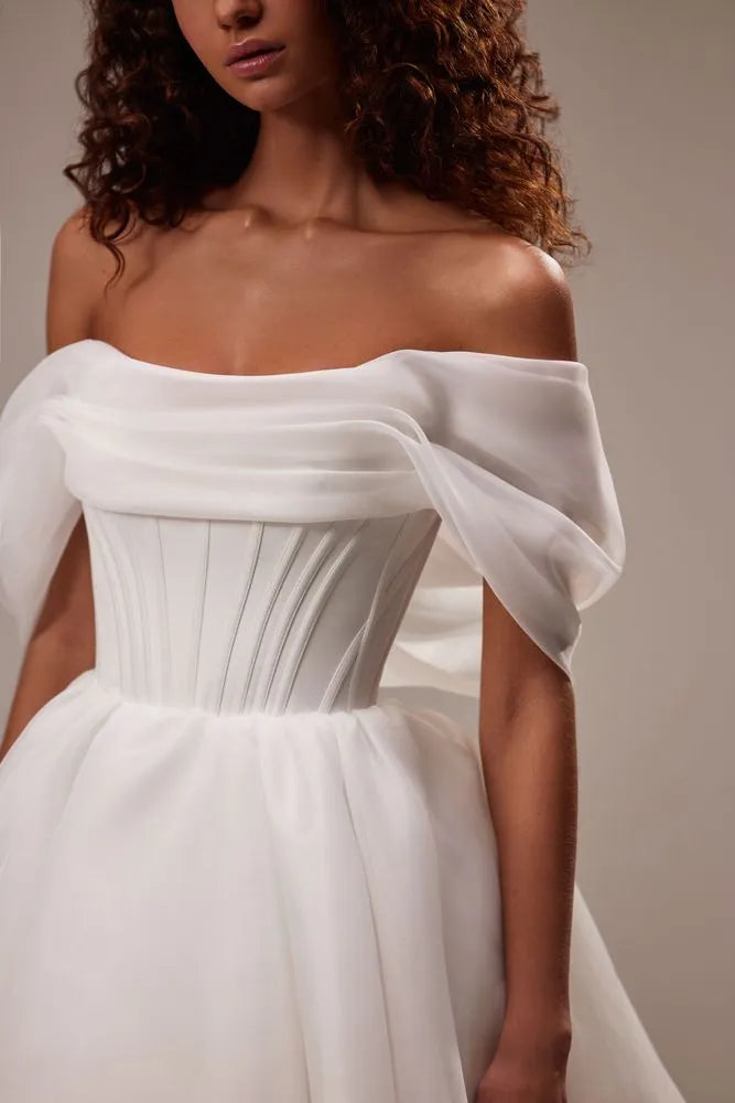 Spectacular off-the-shoulder mini dress cut from flowy organza. Featuring a boned heart-shaped corset with a lace-up closure on the back, and a cute flaring mini skirt.