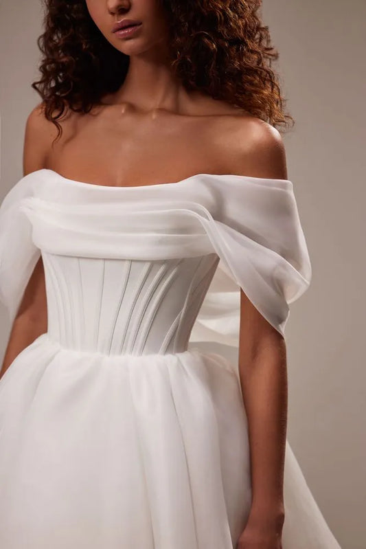 Spectacular off-the-shoulder mini dress cut from flowy organza. Featuring a boned heart-shaped corset with a lace-up closure on the back, and a cute flaring mini skirt.