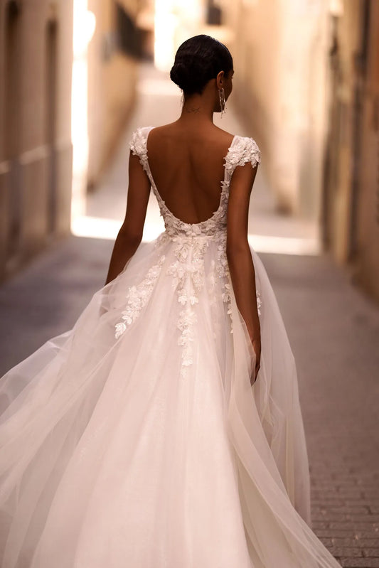 ntroducing our captivating A-line wedding dress, a vision of ethereal beauty and romance. Crafted from delicate tulle fabric, this dress exudes grace and femininity with every step.