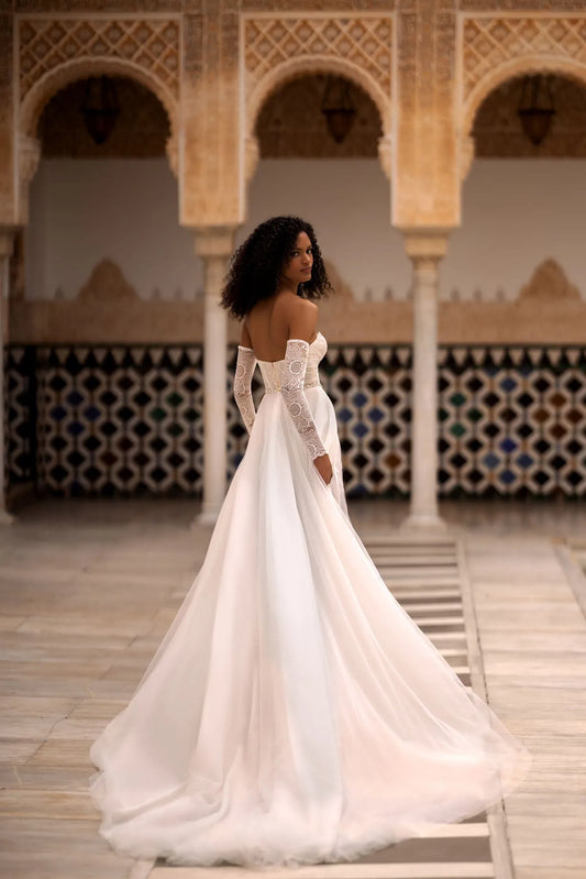 Introducing our stunning two-piece wedding dress, a perfect fusion of modernity and tradition. This exquisite ensemble consists of a short A-line dress and a dreamy tulle overskirt, allowing you to effortlessly transition from ceremony to reception.