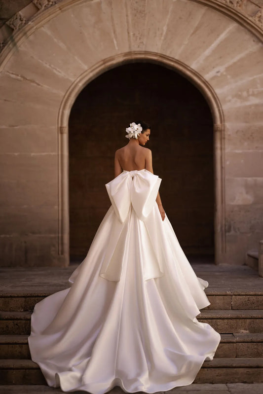 Introducing our captivating A-line wedding dress, a vision of elegance and sophistication. Crafted from luxurious glossy fabric, it exudes a radiant sheen that commands attention and creates a sense of opulence.