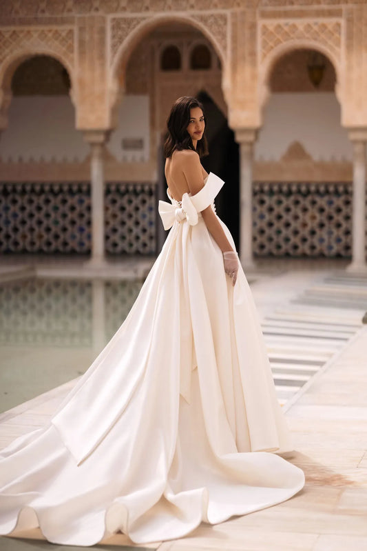 Introducing our glamorous A-line wedding dress, a fusion of sophistication and allure. Crafted from luxurious glossy fabric, it exudes a lustrous sheen that captivates the eye.