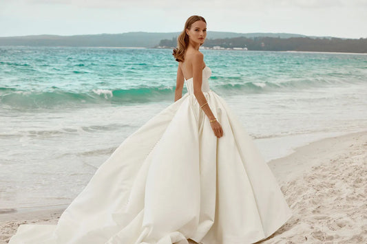 The strapless neckline exudes modern chic, making it a perfect choice for the bride who desires a look that seamlessly blends classic charm with contemporary style on her special day.