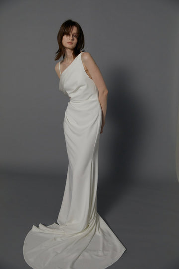 The draped off-shoulder asymmetrical neckline gives a modern take on a classic design wedding dress.