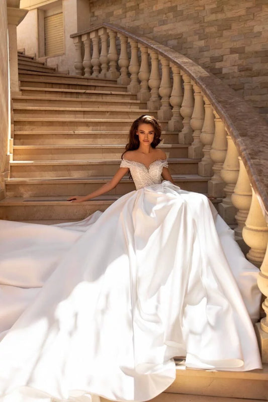 Regal Ball Gown Wedding Dress with Off-Shoulder Neckline, Exquisite Lace Details, and a Flattering Dropped Waist for a Fairytale Bridal Look - Camilla's