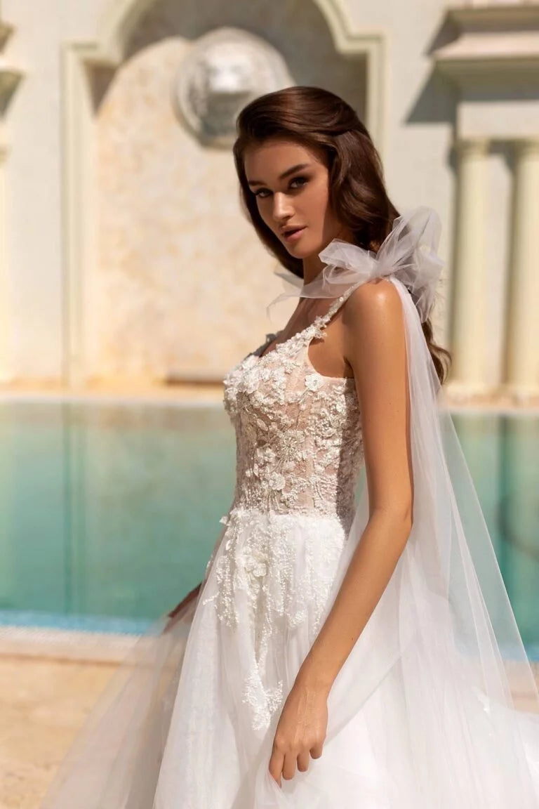 Ethereal A-Line Wedding Gown with Spaghetti Straps, V-Neckline, and a Graceful Dropped Waist for a Romantic Bridal Look