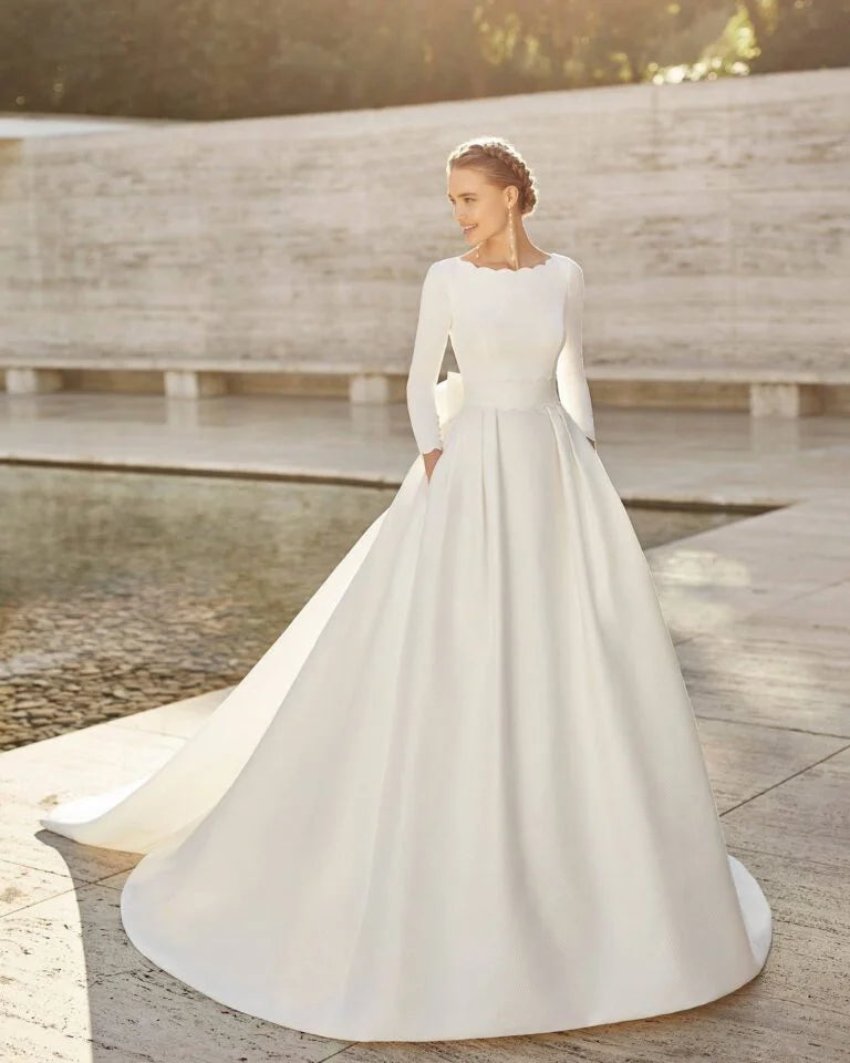 Elegant A-Line Wedding Gown with Exquisite Lace Detailing, Graceful Long Sleeves, a Sophisticated Boat Neckline, and a Flattering Dropped Waist for a Timeless and Regal Bridal Look