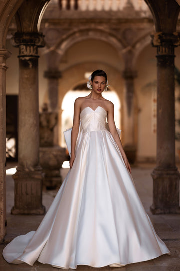 Introducing our captivating A-line wedding dress, a vision of elegance and sophistication. Crafted from luxurious glossy fabric, it exudes a radiant sheen that commands attention and creates a sense of opulence.