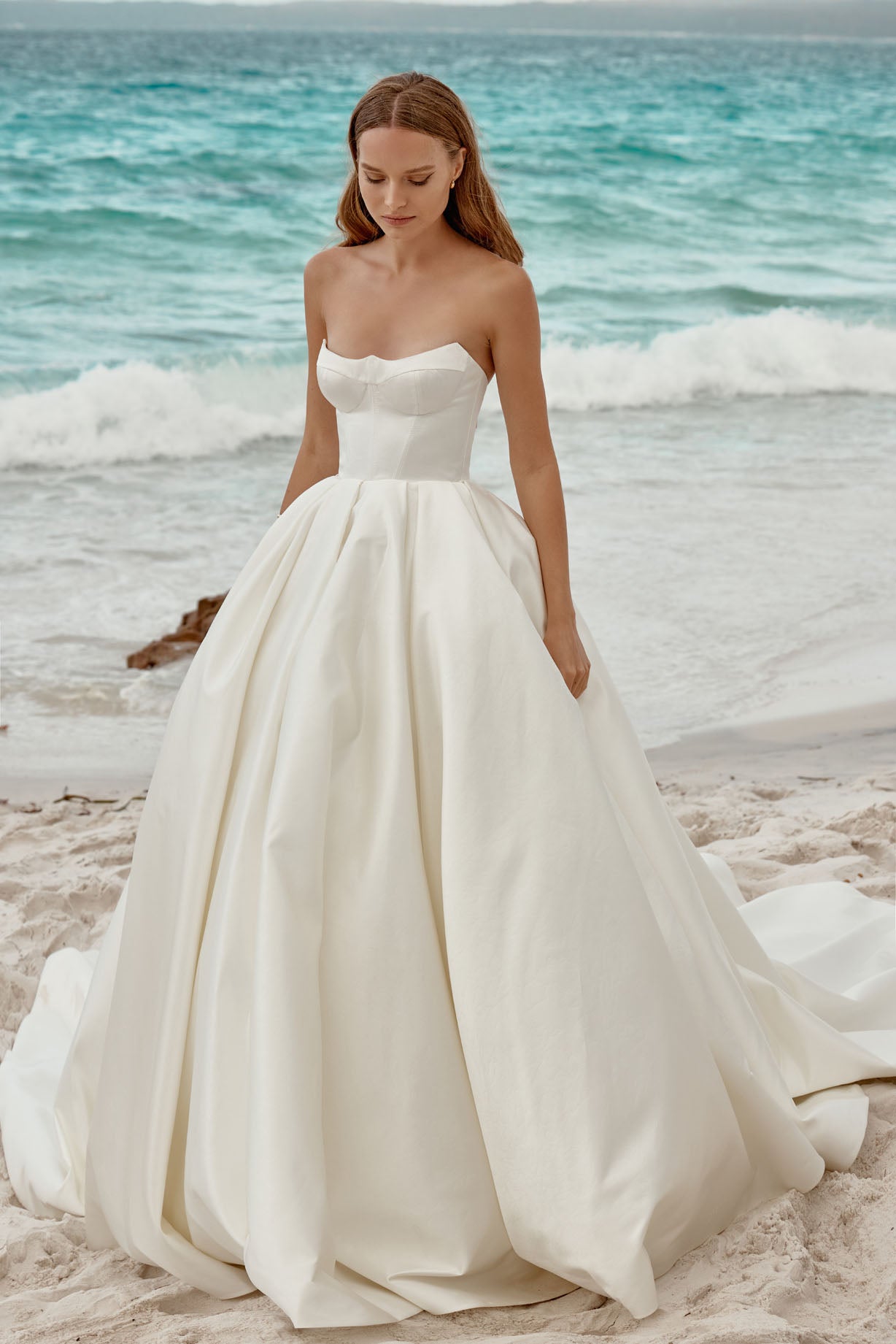 The strapless neckline exudes modern chic, making it a perfect choice for the bride who desires a look that seamlessly blends classic charm with contemporary style on her special day.