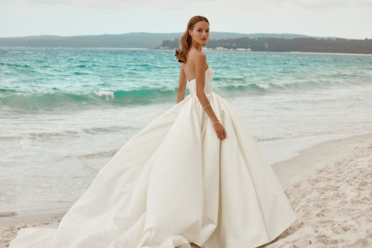 The strapless neckline exudes modern chic, making it a perfect choice for the bride who desires a look that seamlessly blends classic charm with contemporary style on her special day.